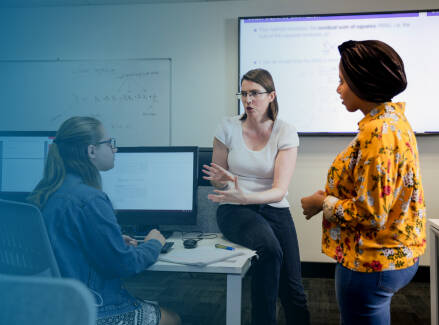 Two instructors talking to a student